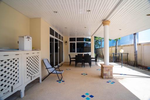 Spacious covered patio area with dining set and BBQ grill