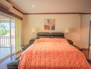 Spacious bedroom with large bed, hardwood floors and balcony access