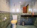 Tiled bathroom with toilet and washbasin