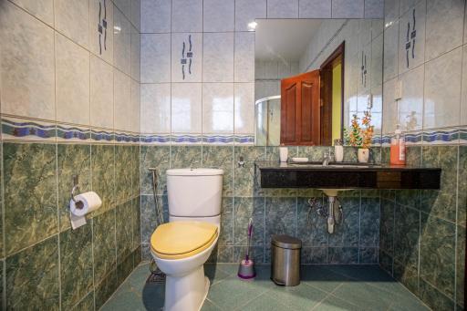 Tiled bathroom with toilet and washbasin