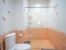 Brightly lit bathroom with shower enclosure and orange tiles