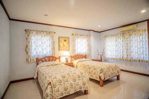 Bright and spacious twin bedroom with floral bedding and curtains
