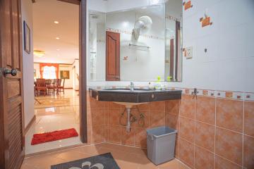 Spacious tiled bathroom with large mirror and modern sink