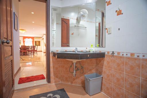 Spacious tiled bathroom with large mirror and modern sink