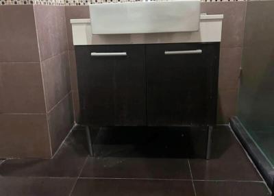 Modern bathroom interior with brown tiles and a sink cabinet