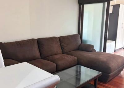 Cozy living room with brown sofa and wooden flooring