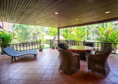 Spacious covered patio with seating area and garden view