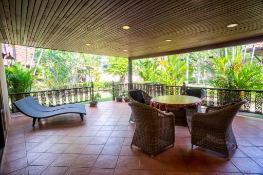 Spacious covered patio with seating area and garden view