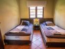 Cozy twin bedroom with terracotta floor tiles