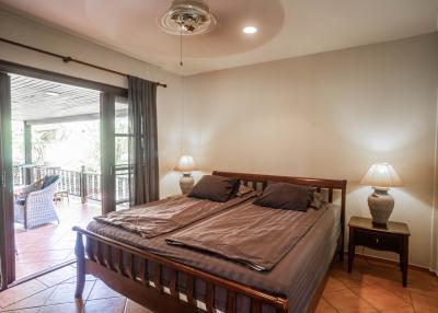 Spacious bedroom with a king-sized bed, nightstands, and balcony access