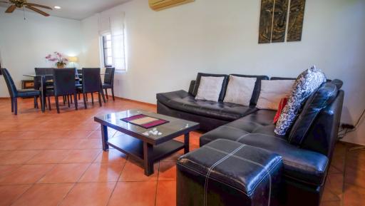 Spacious living room with leather sofa and dining area