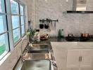 Modern kitchen with stainless steel appliances and marble walls