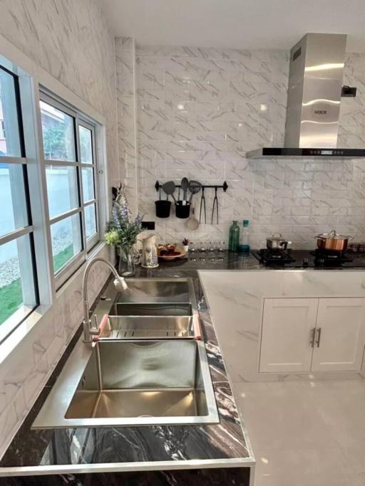 Modern kitchen with stainless steel appliances and marble walls