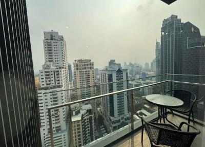 High-rise balcony with city view and outdoor seating