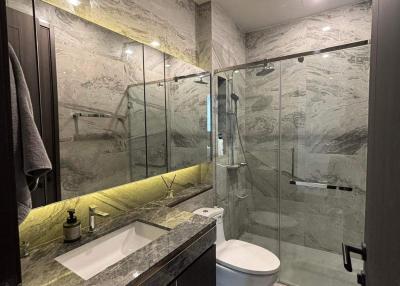 Marble tiled bathroom with glass shower and modern fixtures