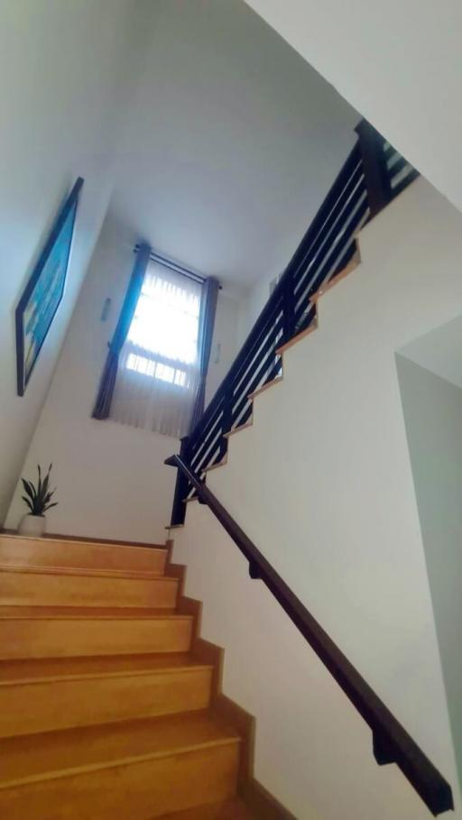 Well-lit staircase with wooden steps and a secure handrail