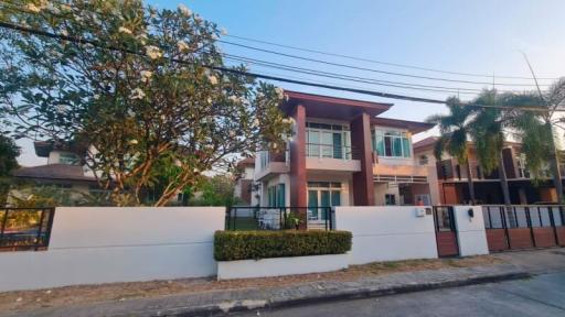 Modern two-story house with gated entrance and landscaping