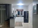 Modern kitchen with open layout, stainless steel appliances, and ample lighting