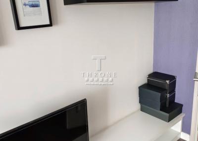Modern living room with wall-mounted shelf and sleek entertainment unit