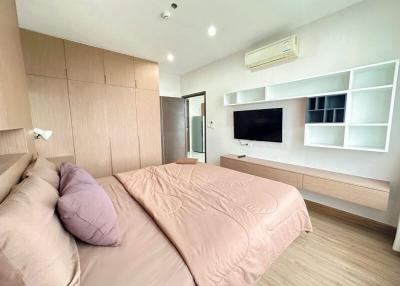 Modern bedroom interior with king-sized bed, built-in wardrobes and flat screen TV