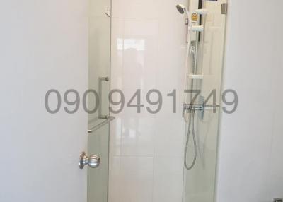 Modern white tiled bathroom with glass shower and stainless steel fixtures