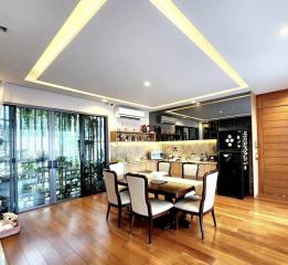Modern dining room with kitchen counter and glass walls overlooking outdoor area