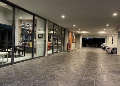 Spacious living area integrated with luxury garage featuring tiled flooring, modern furniture, and large glass windows