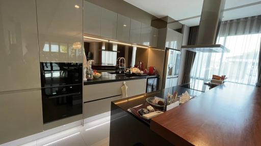 Modern kitchen with reflective surfaces and plenty of natural light
