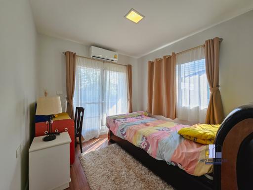 Bright cozy bedroom with a single bed and air conditioning unit