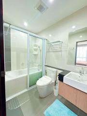 Modern bathroom with glass shower enclosure, bathtub, and vanity