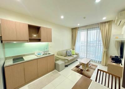 Modern open-plan living room with adjoining kitchen and ample natural light