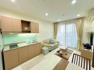 Modern open-plan living room with adjoining kitchen and ample natural light