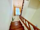 Wooden stairway with chandelier and window