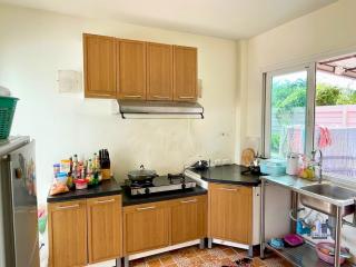 Compact kitchen with wooden cabinets and stainless steel sink