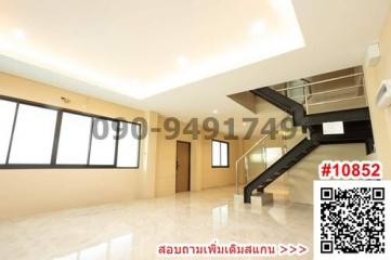 Spacious living room with modern staircase and tiled flooring