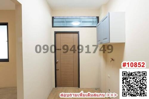 Compact space featuring entry door, overhead storage, and wall-mounted air conditioning unit