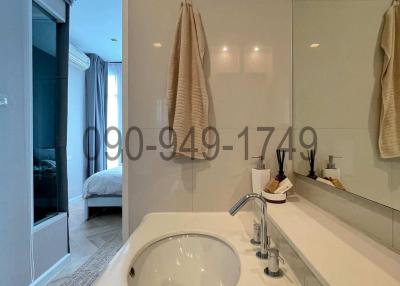 Modern bathroom with sink and view into bedroom