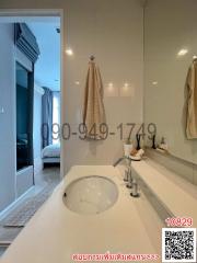 Modern bathroom with sink and view into bedroom