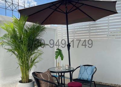 Cozy outdoor patio seating area with umbrella and decorative plants