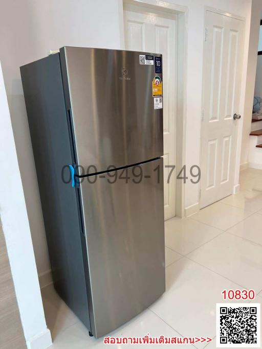 Modern stainless steel refrigerator in a kitchen with white interior