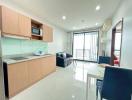 Modern kitchen with wood cabinets and integrated appliances leading to a cozy balcony