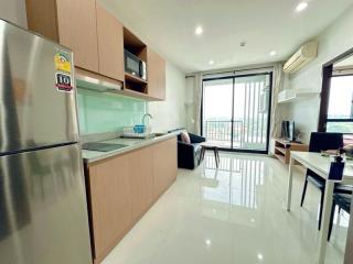 Spacious and modern apartment interior with open-plan kitchen, living and work area, bright natural light