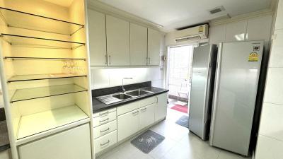 Modern kitchen with white cabinets, stainless steel refrigerator, and built-in sink