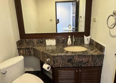 Contemporary bathroom with marble countertop and large mirror