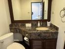 Contemporary bathroom with marble countertop and large mirror