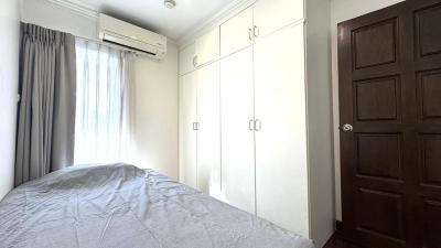 Cozy bedroom with a large bed, built-in wardrobes, and an air conditioning unit