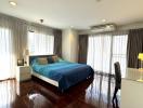 Spacious bedroom with hardwood floors and ample natural light