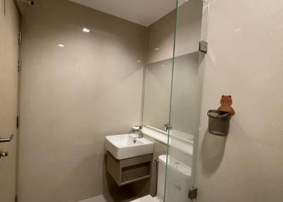 Modern bathroom with glass shower enclosure and neutral tones