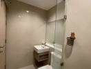 Modern bathroom with glass shower enclosure and neutral tones