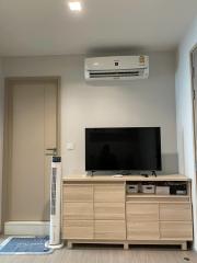 Modern living room with wall-mounted TV and air conditioning unit